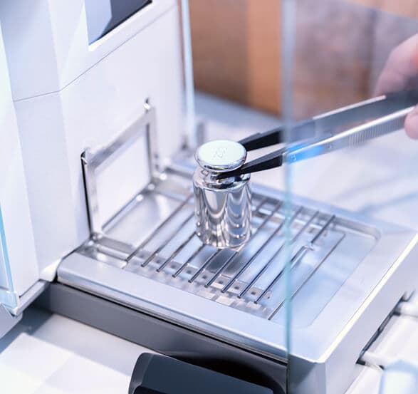weighing platform of a precise electronic balance in a laboratory setting.